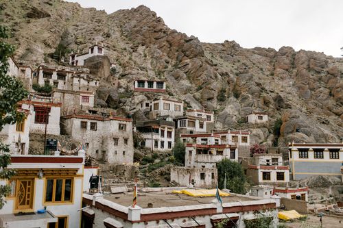 Free Aged stone shabby buildings located on rocky slope in mountainous area in countryside against cloudless sky in rural place in nature Stock Photo