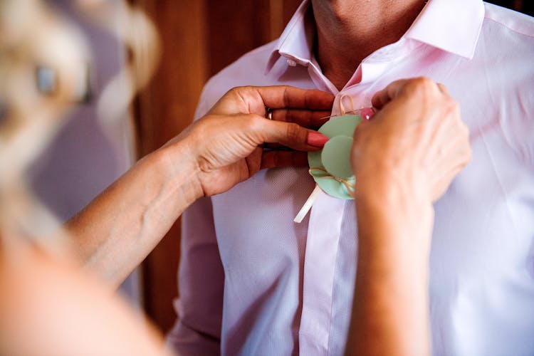 Woman Fastening Clip To Mans Shirt 