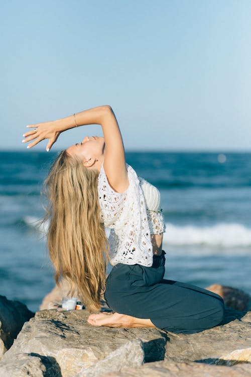Free Woman Doing Yoga Near Sea Stock Photo