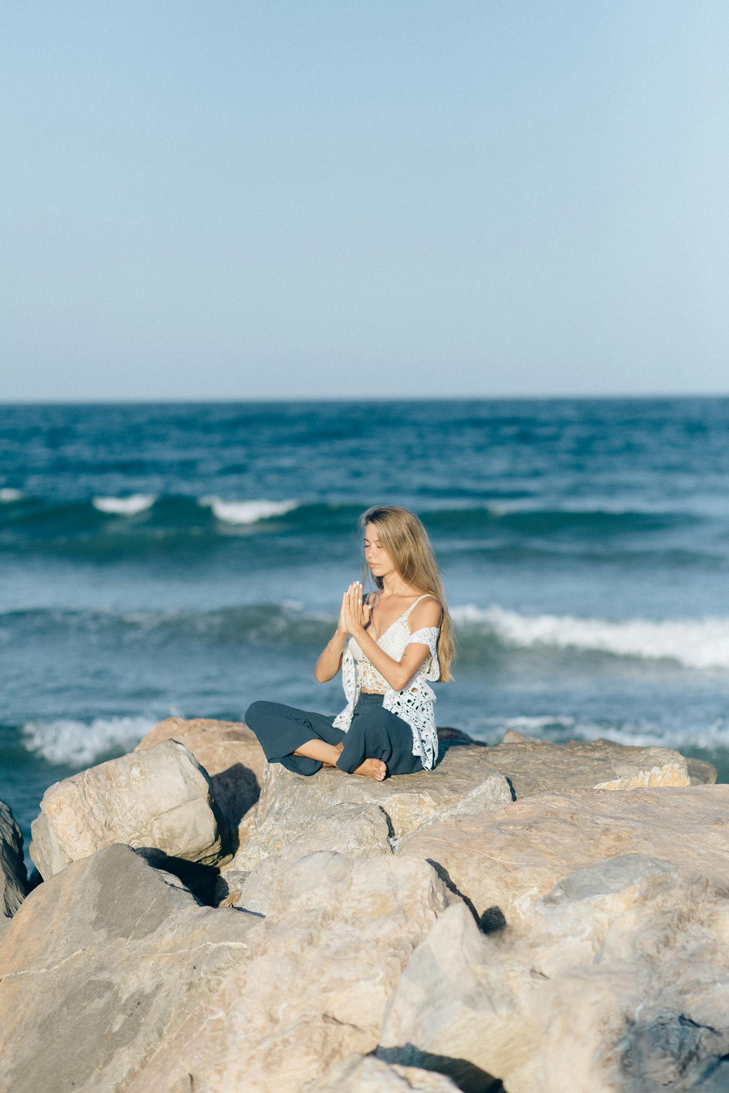 Woman in White and Black Dress Sitting on Rock Near Sea · Free Stock Photo