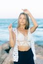 Woman in White Lace Brassiere and Panty Standing on Rock Near Sea
