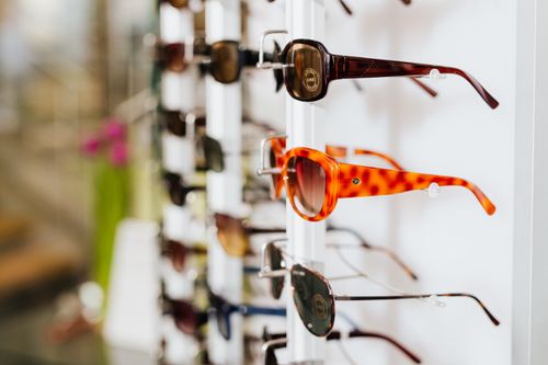 Free A vibrant assortment of fashionable sunglasses displayed on a store rack, ready for a trendy sale. Stock Photo
