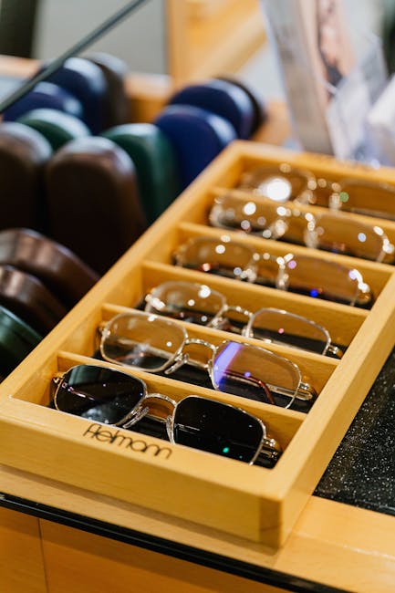 A collection of eyeglasses neatly arranged in a wooden tray at an eyewear store.
