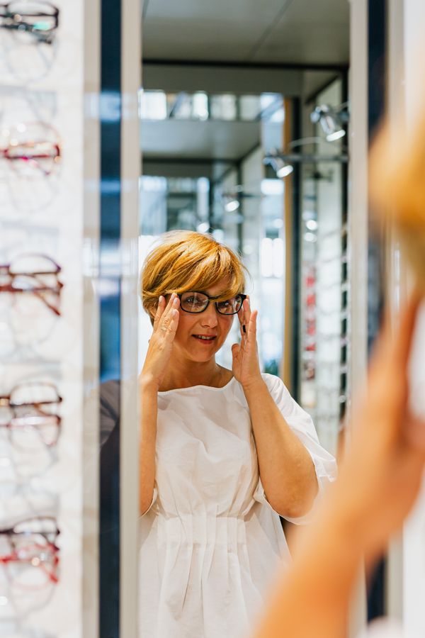 Customer trying designer eyeglasses at our optical store in Lahar