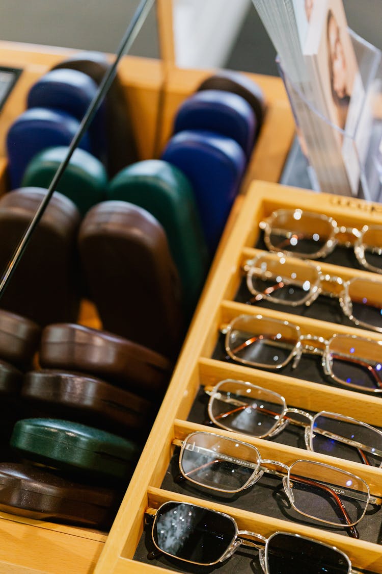 Eyeglasses And Cases On Wooden Rack