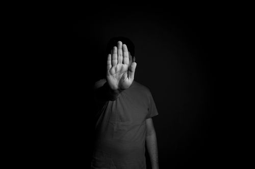 Free Dramatic black and white image of a man presenting a stop hand gesture, symbolizing refusal. Stock Photo