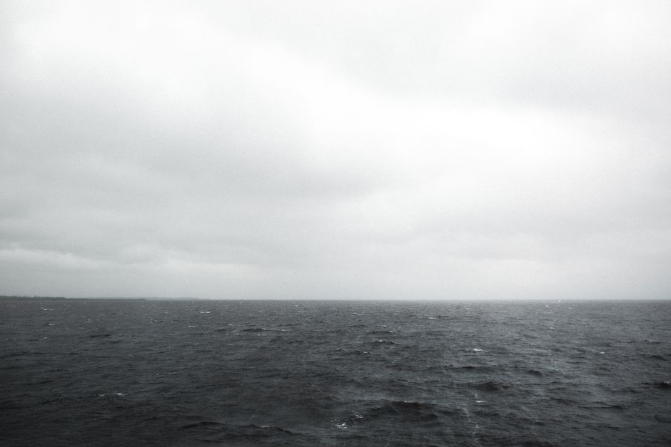A dramatic and gloomy seascape in Norfolk with overcast skies and choppy waters.