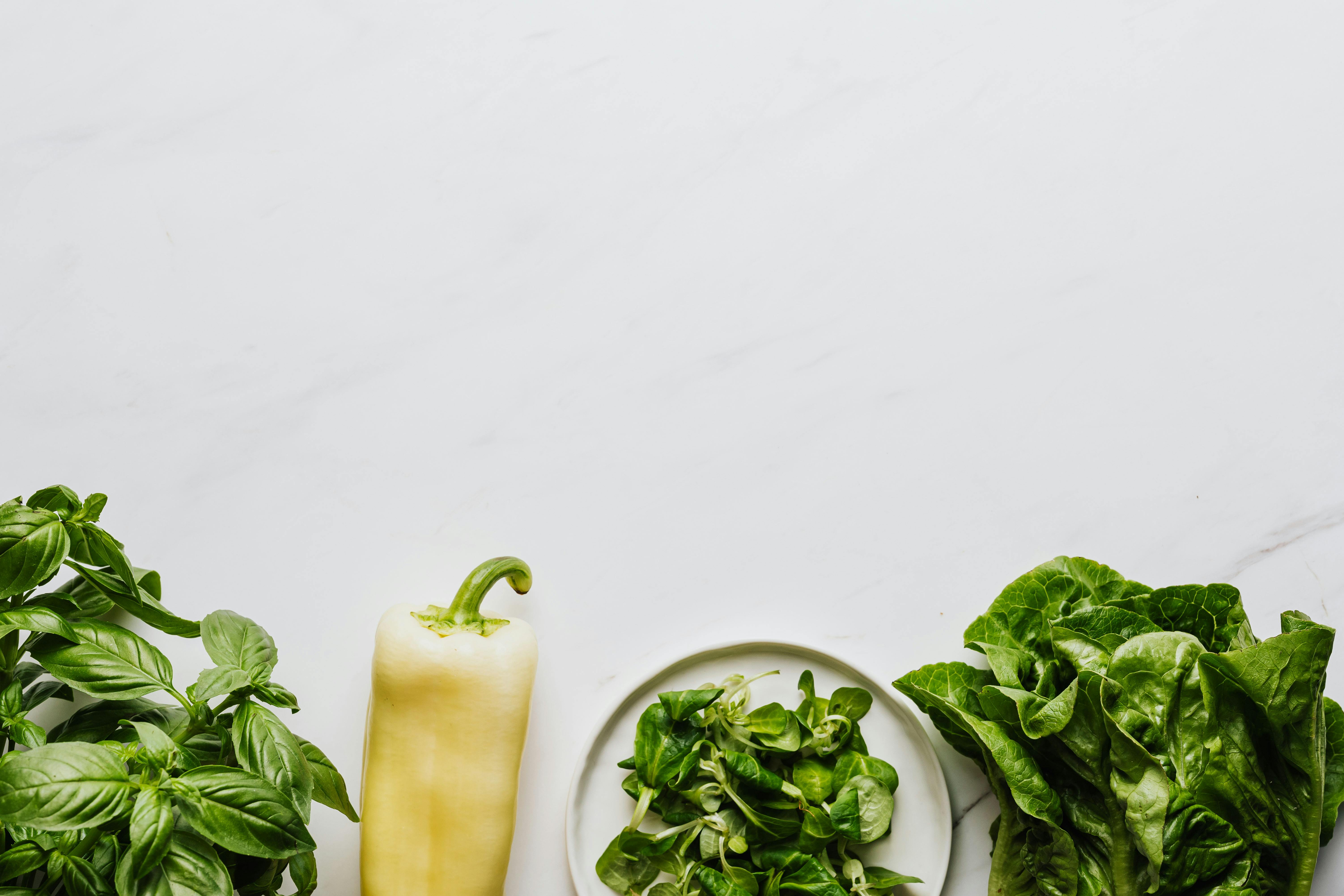 bell pepper and leafy vegetables on a flat surface