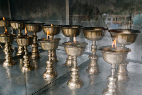 Buddhist lamps with burning candles in old church