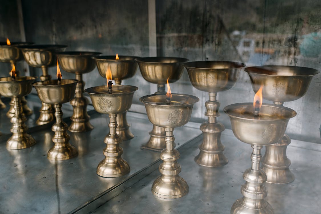 Free Buddhist lamps with burning candles in old church Stock Photo