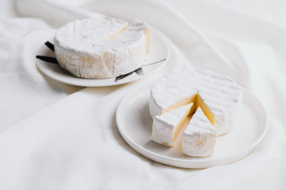 Queso de leche cruda francés tradicional cortado en cuñas sobre tabla de madera