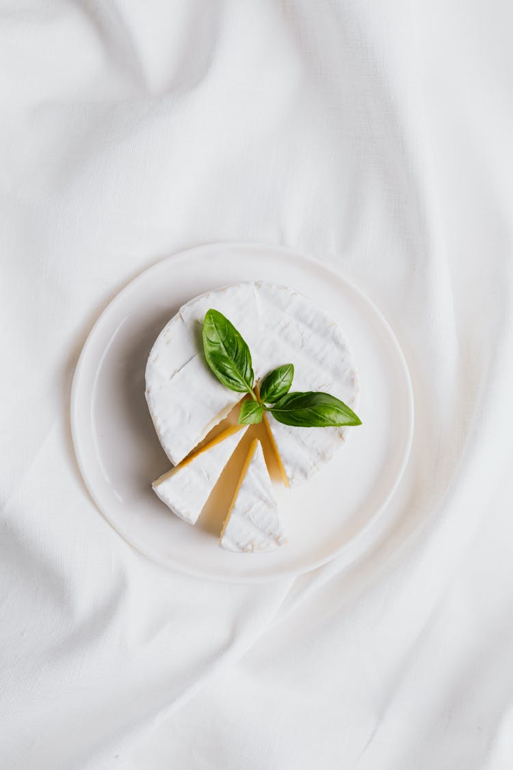 Sliced Cheese On A Plate Over A White Cloth