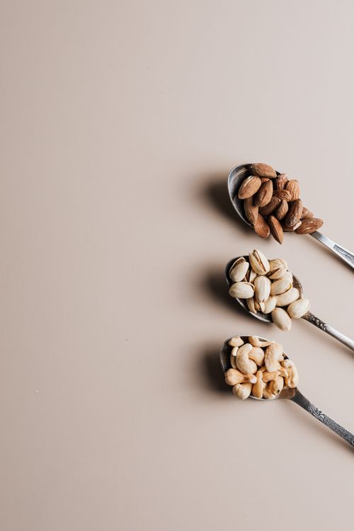 Free Flat lay of assorted nuts on spoons with empty copy space, perfect for healthy food concepts. Stock Photo