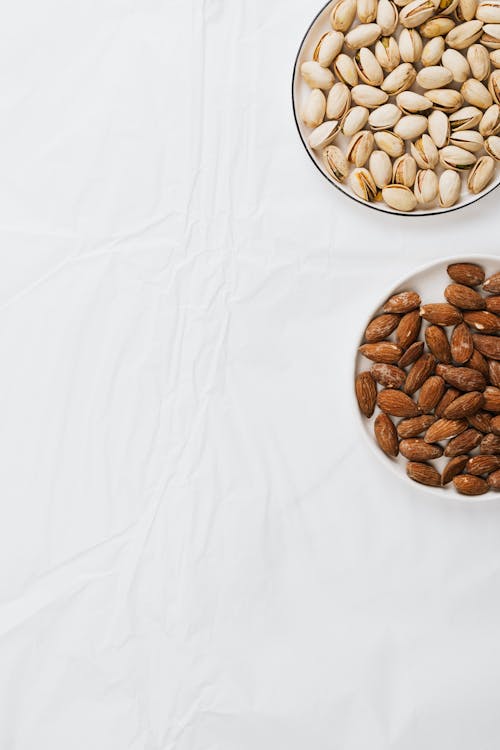 Free Nuts on Plates On a White Surface Stock Photo