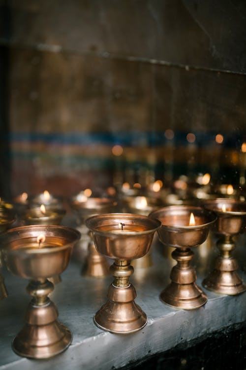 Metal bowls with burning candles in Asian church