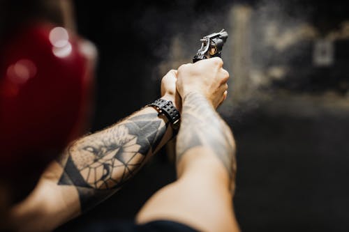 A Person Holding Black and Silver Revolver Pistol