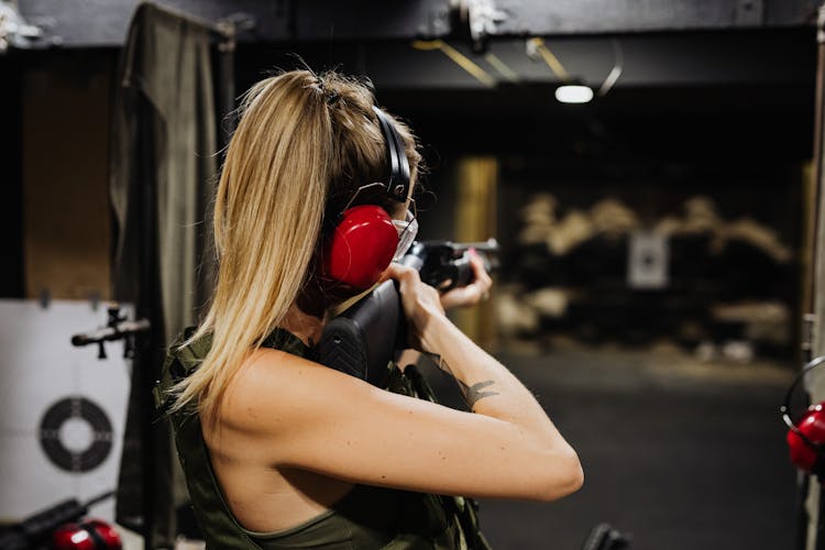 A Woman In Black Tank Top Holding Black Rifle