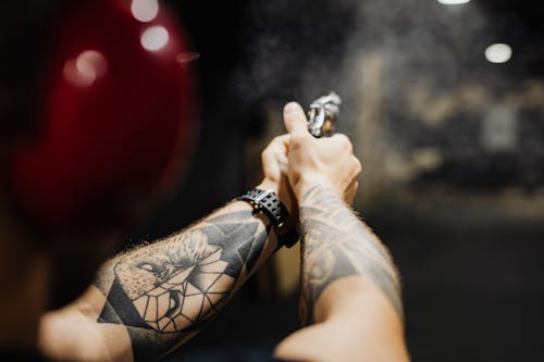 Gratis stockfoto met arm tatoeage, depth of field, geweer