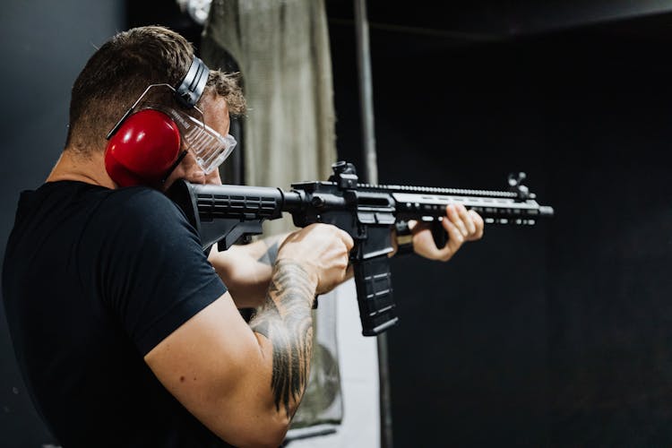 A Man Aiming A Rifle