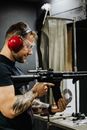 A Tattooed Man Reloading a Rifle