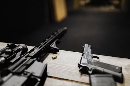 A Rifle and a Handgun on a Desk