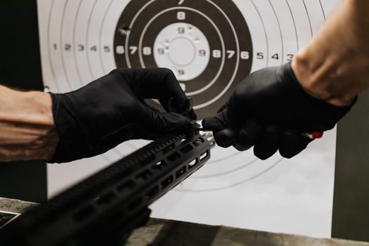 A Person Tightening the Iron Sight of a Rifle
