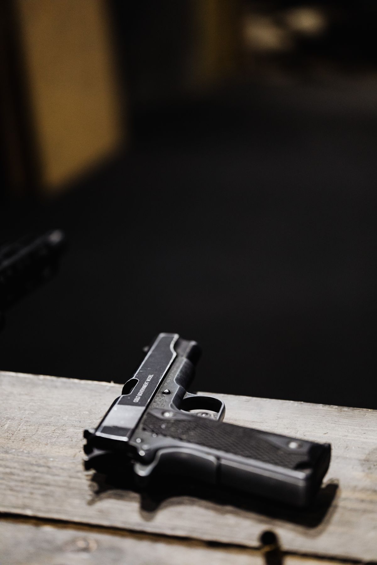 Pistola sobre superfície de madeira, arma de fogo de uso permitido citada no Estatuto do Desarmamento
