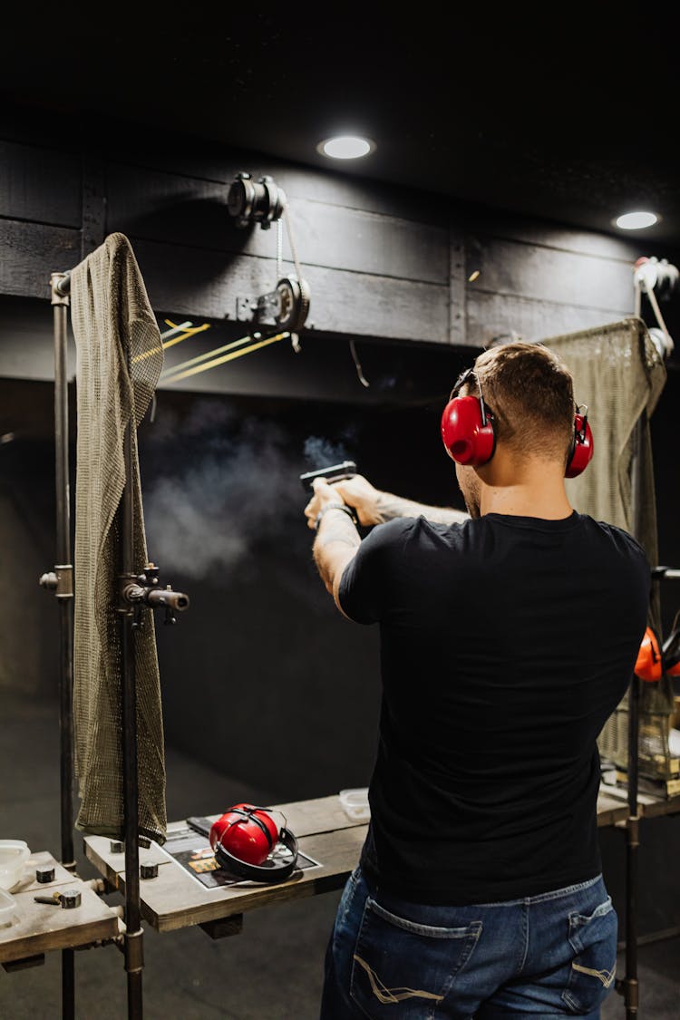 A Man In Black Shirt Firing Gun