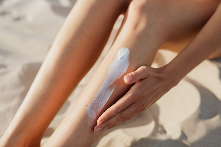 A Person Applying Cream On A Leg