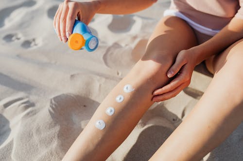 Free Photograph of a Person Putting White Cream on Her Leg Stock Photo