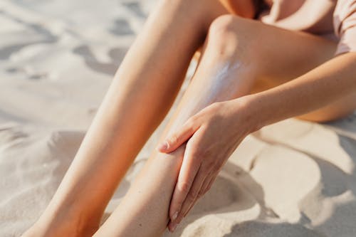 Free A Person Applying Cream on Her Leg Stock Photo