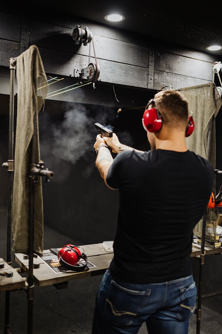 Man In Black Crew Neck T-shirt Firing A Gun