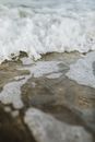海浪宁静，泡沫冲刷沙滩，展现了大自然的静谧