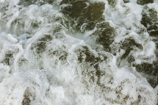Powerful ocean waves creating sea foam in a close-up shot, capturing the energy and movement of the sea.
