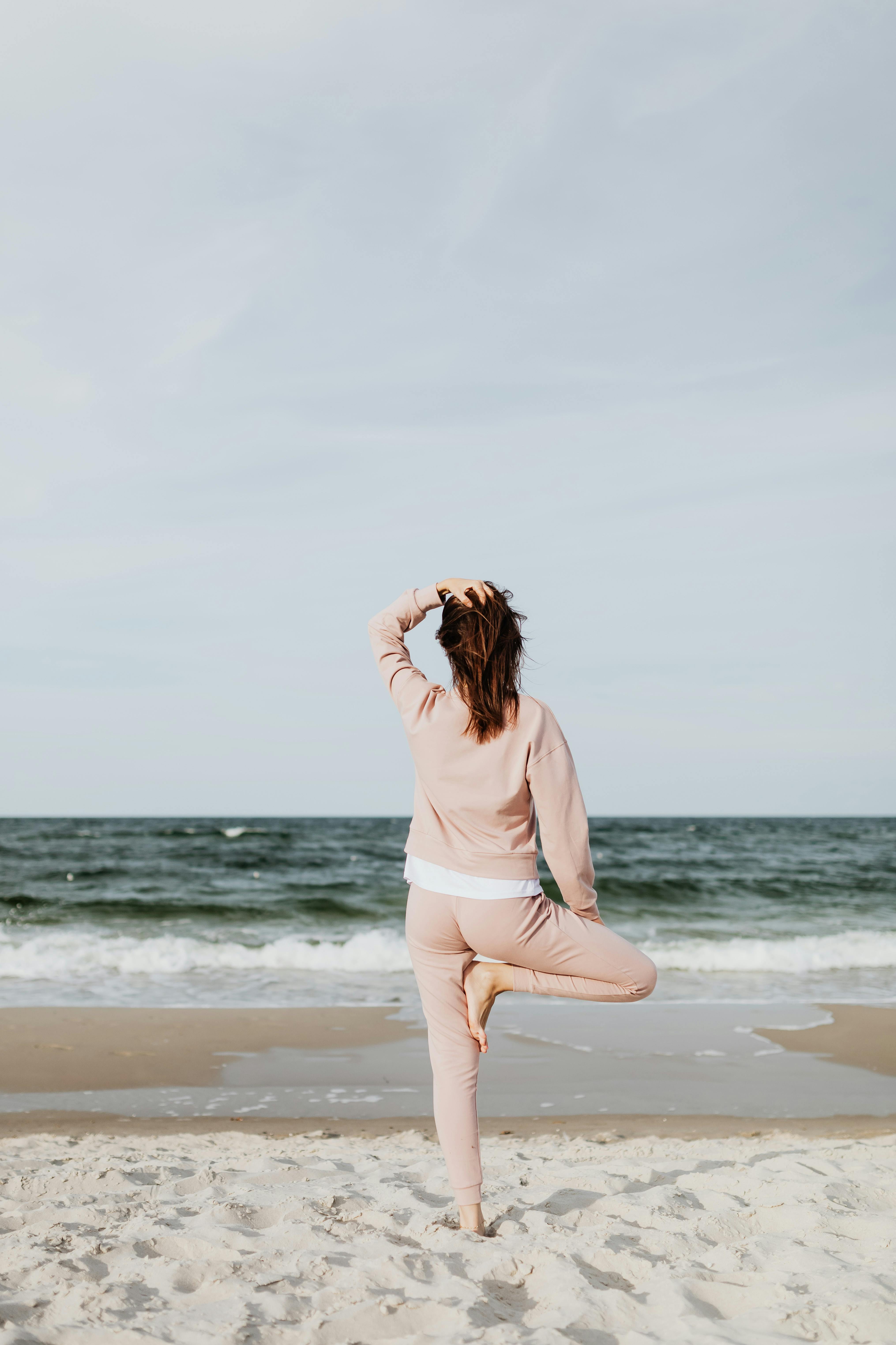 woman standing holding her head while her leg up