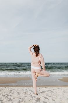 女子在沙滩上练习瑜伽，尽显宁静与平衡
