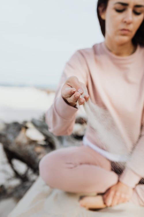 Free Woman in Pink Long Sleeve Shirt Playing With Sand Stock Photo