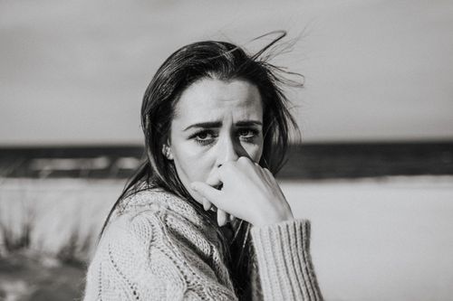 Free A monochrome portrait of a woman with pensive expression at the beach. Stock Photo
