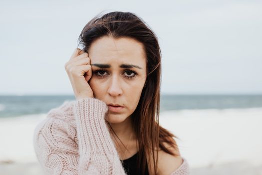 一位在海滩上沉思的女人的肖像