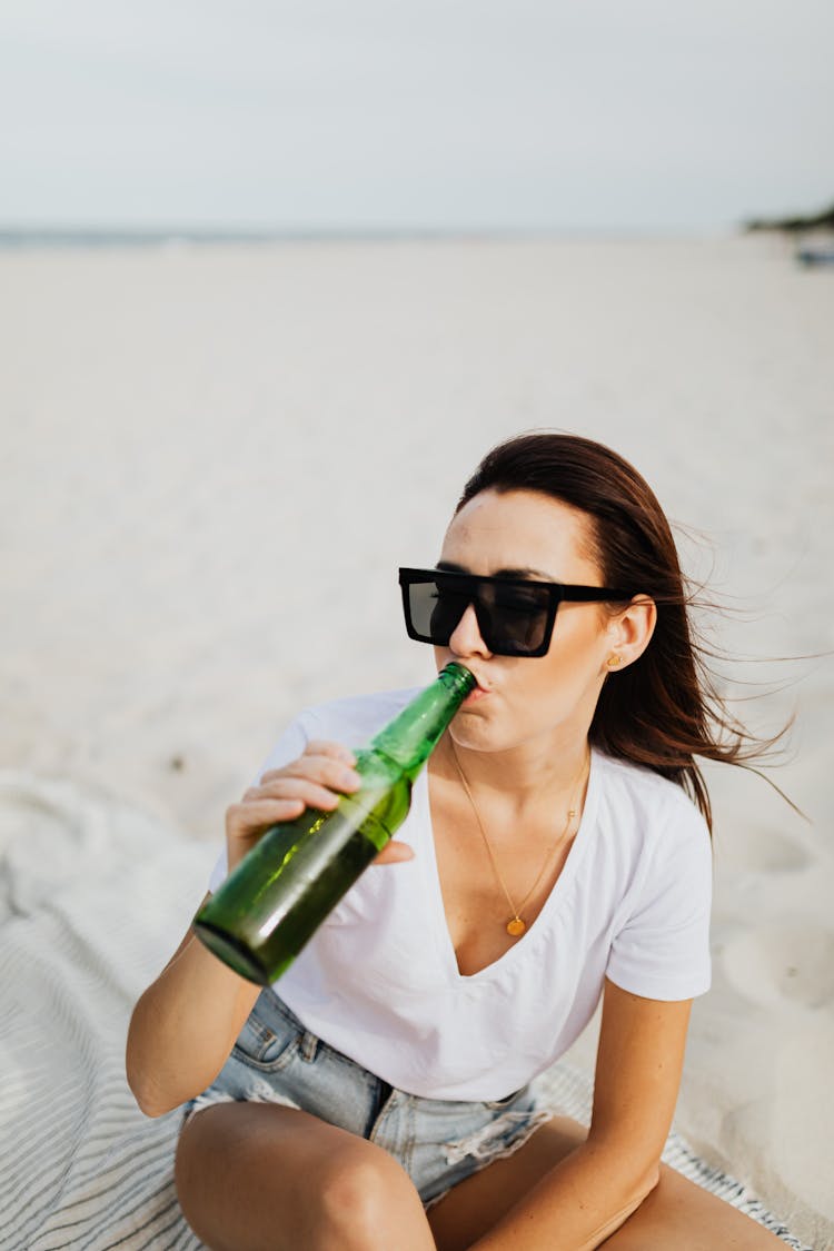 Woman In White Crew Neck T-shirt With Black Sunglasses Drinking A Bottle Of Beer