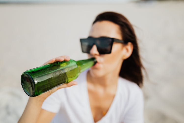 Woman In White Shirt Drinking Beer In Bottle