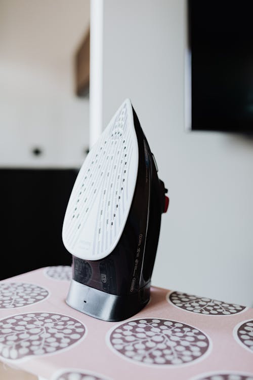 Free Black Clothes Iron on a Ironing Board Stock Photo