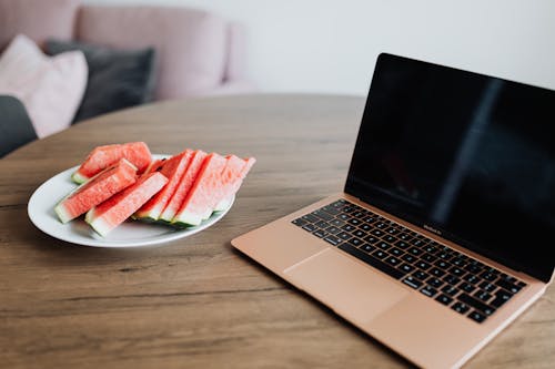 Free Macbook Pro on Brown Wooden Table Stock Photo