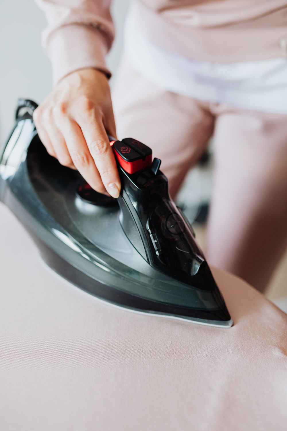 Using A Iron Person Using a Black Clothes Iron · Free Stock Photo