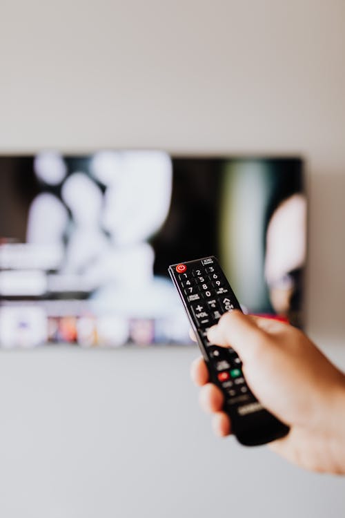 Person Holding a Black Remote Control