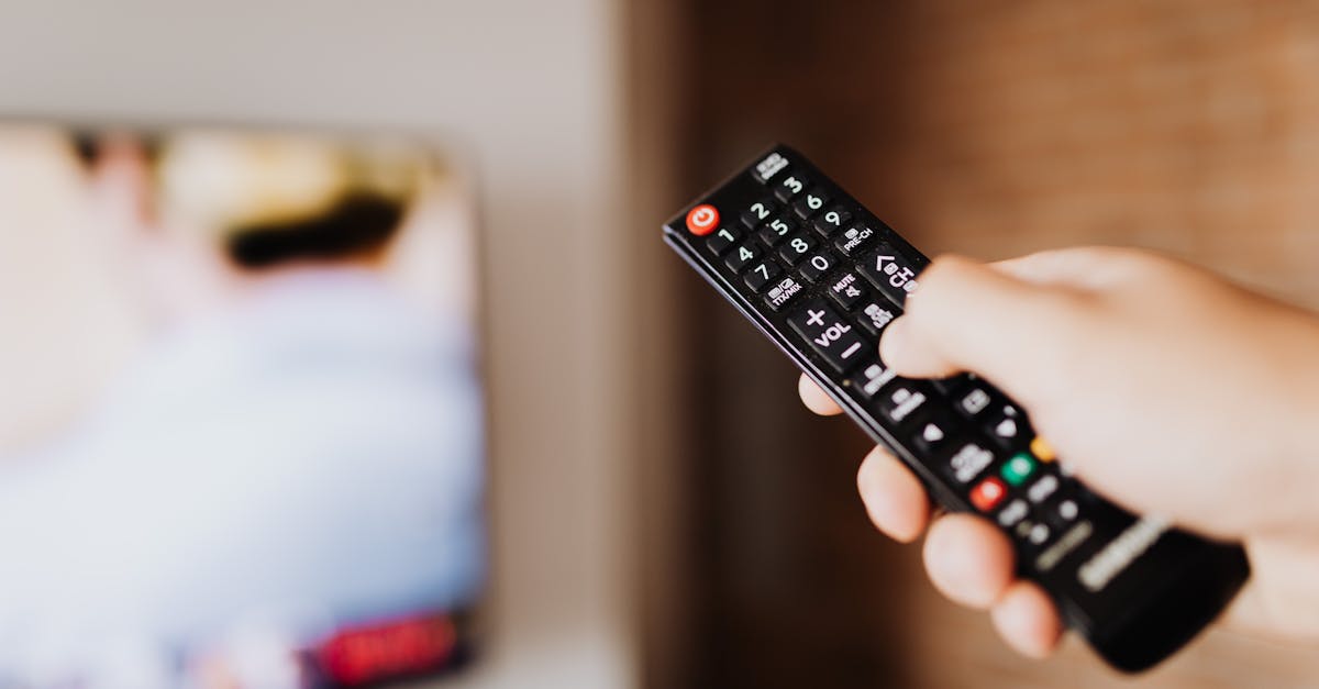 Person Pressing the Button of a Remote Control · Free Stock Photo