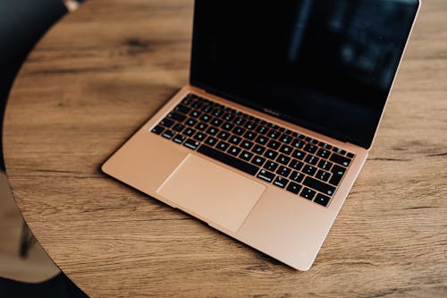 Macbook Pro on Brown Wooden Table