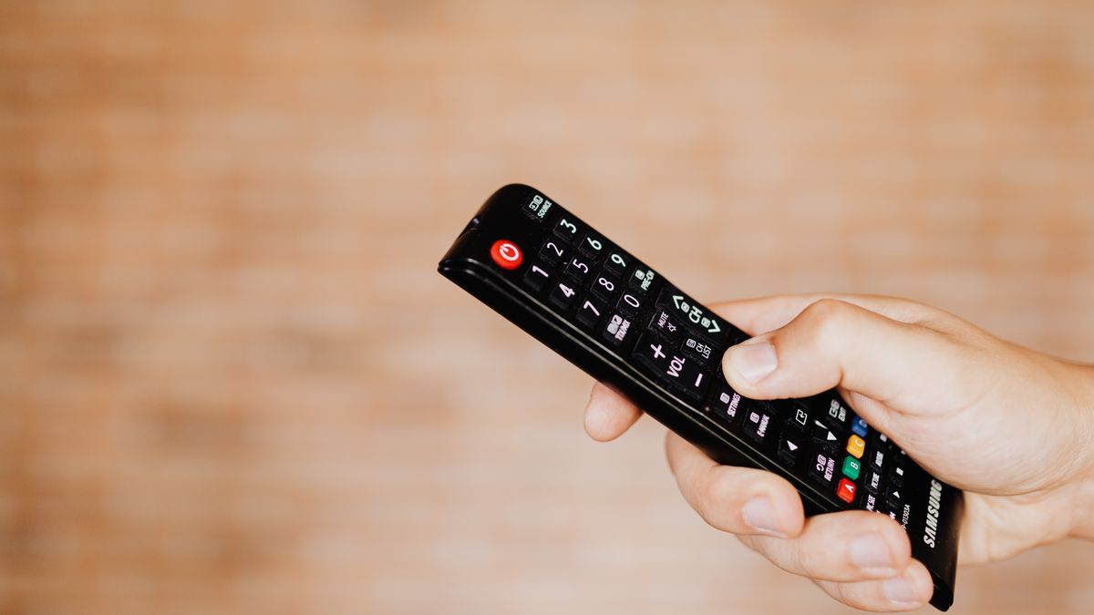 テレビのリモコンを持つ手元