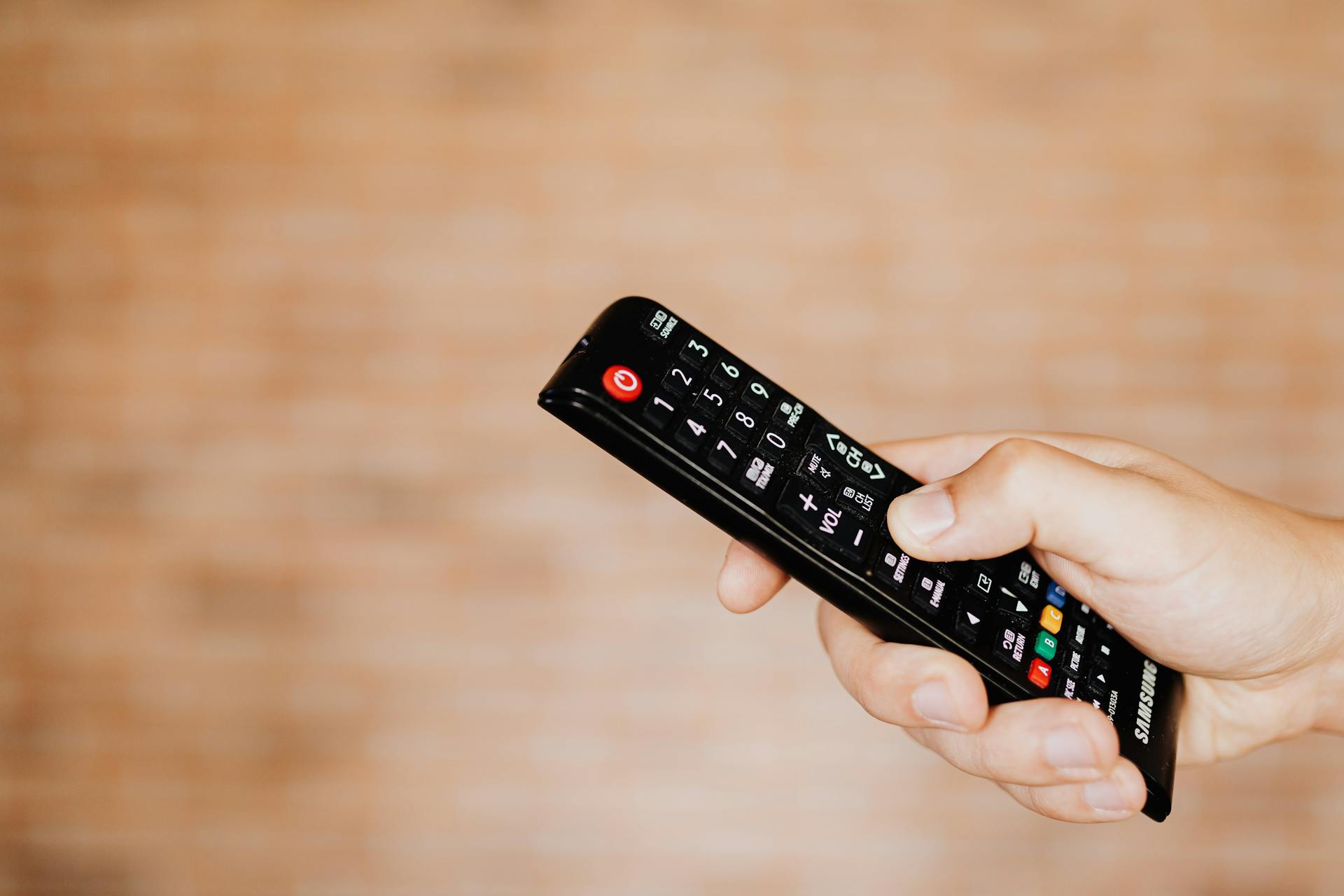 Person Holding a Black Remote Control