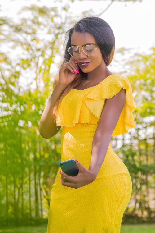 Woman in Yellow Dress Taking Selfie with Smartphone